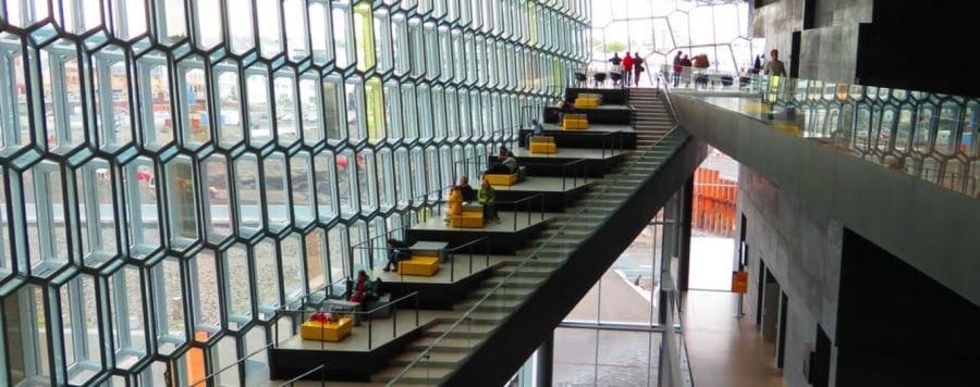 Photo of busy commercial building with stairs running alongside seating area. Walk-way to the right