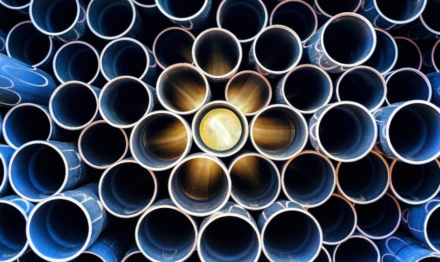 Abstract pattern of scratched pvc pipe piled up with sun lights coming through the middle
