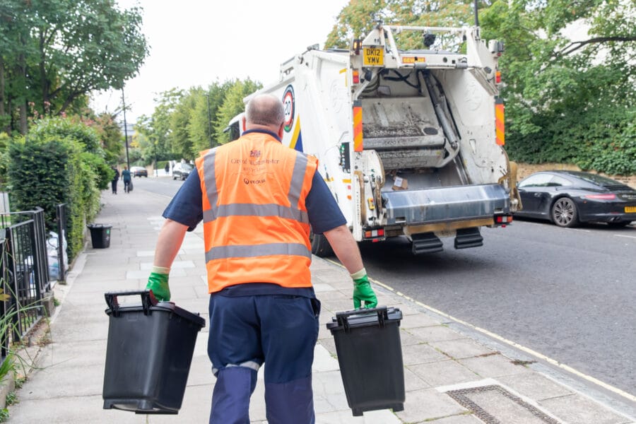 City of Westminster, Veolia bin crew collecting commercial waste: man wearing an orange high-vis carrying two food waste bins towards bin truck. Image credit: Westminster Council